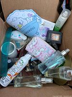 Top view of open box showing sprays, pouch, plush, mug, ruler, cosmetics, bowl