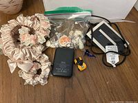 Lot overview showing scrunchies, power bank, seashell bag, toy car, glass dolphin, wired pad