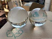 two clear crystal spheres on cardboard surface