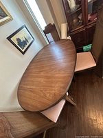 Full view of oval wood dining table and some chairs