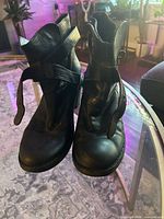 Front view of Fiorentini + Baker black leather ankle boots showing strap detail