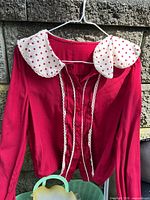 Front view of red blouse showing polka dot collar and lace trim