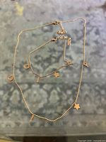 Necklace and bracelet laid out showing letter and star charms
