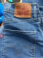 Light wash Levi’s jeans showing back pocket, red tab, leather patch