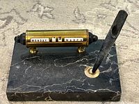 Overall view of black marble base, brass barrel calendar and stone pen