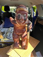 Front view of terracotta figure holding cane
