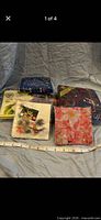 Five sealed packs of vintage paper napkins laid out with measuring tape for scale