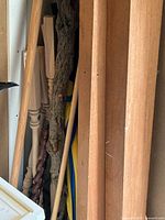 Long hardwood boards and mixed wood pieces standing in corner
