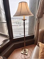 Full view of brass floor lamp with shade