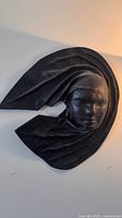 Overall view of black resin wall sculpture mounted on wall