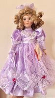 Front view of Vanessa porcelain doll in lavender outfit