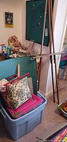 Overall view showing easel, cork board, storage tote, cutting mat, pillow and surrounding craft items