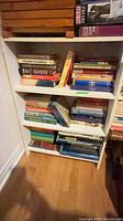Front view of white 3-shelf bookcase with books (contents not included)