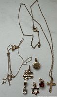 All items laid out: two chains, seven pendants detailing shapes and stones