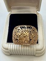 Ring in presentation box, front view shows filigree pattern