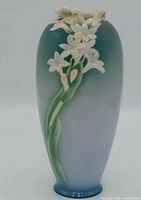 Full front view of vase showing color gradient and floral relief