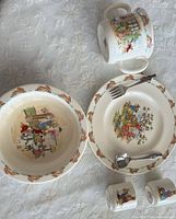 Plate, bowl, two-handled mug, fork & spoon, two small cups