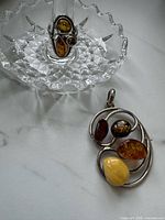 Pendant and ring displayed on glass dish