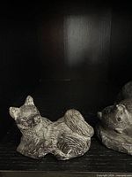 Left figurine wolf pup, right bear cubs on rock, shows scale and detail