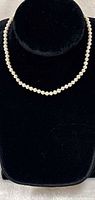 Necklace displayed on black bust showing full strand