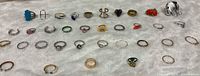 Wide view showing entire assortment of rings on fabric backdrop
