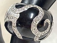 Close-up of ring showing black enamel dome and CZ swirl detailing