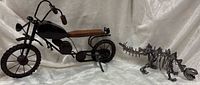 Overall view of metal motorcycle and welded dinosaur
