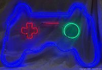 Neon sign illuminated showing blue outline, red D-pad, red bar, green circle