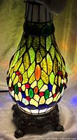 Lamp base illuminated showing stained glass colors and jewel accents