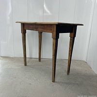 Three-quarter view of entire table showing plank top, legs and finish