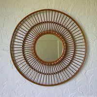 Full view of rattan sunburst mirror hanging on wall