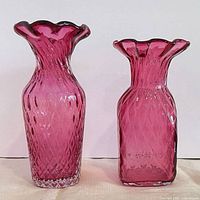 Front view of both cranberry glass vases showing shape and color