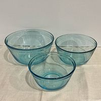 Three graduated aqua glass bowls grouped