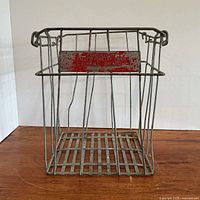 Full view of metal wire crate on wood surface