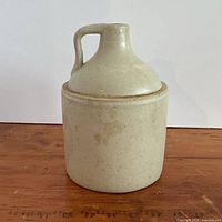 Front view of light tan stoneware crock jug with handle