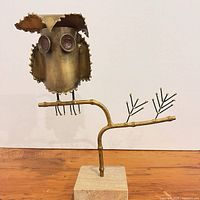 Front view of brass owl sculpture on stone base