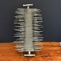 Full frontal view of welded steel rod sculpture standing vertically