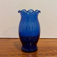Full front view of cobalt blue ruffled rim glass vase
