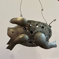 profile view showing pierced body, legs, wire handle and hook