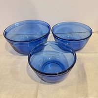 Front angled view of all three blue glass nesting bowls