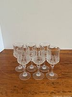 Front view of six matching cut glass stemmed wine glasses