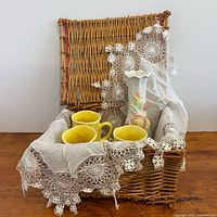 All items grouped in wicker basket showing mugs, vase, runner, basket