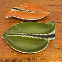 Top view of orange and green leaf plates on table