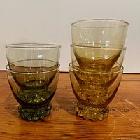 Side view showing one olive green glass and three amber glasses stacked