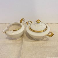 Top view of creamer and lidded sugar bowl showing gold trim and interiors