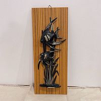 Full view of plaque front showing fish figures and wood grain