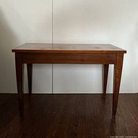 Coffee table closed, front view showing tapered legs and wood finish