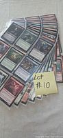 Stack of ten binder sleeves fanned out displaying MTG cards
