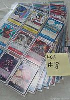 Stack of plastic sleeves filled with assorted One Piece cards, sticky note identifies lot