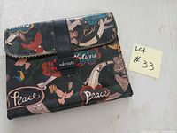 Front of Sakroots tablet case showing multicolor print and strap closure